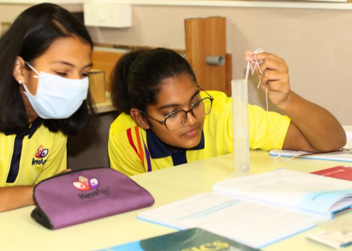 Students conducting hands-on science experiments in the lab at NewAge World School, an international school in Bangalore.