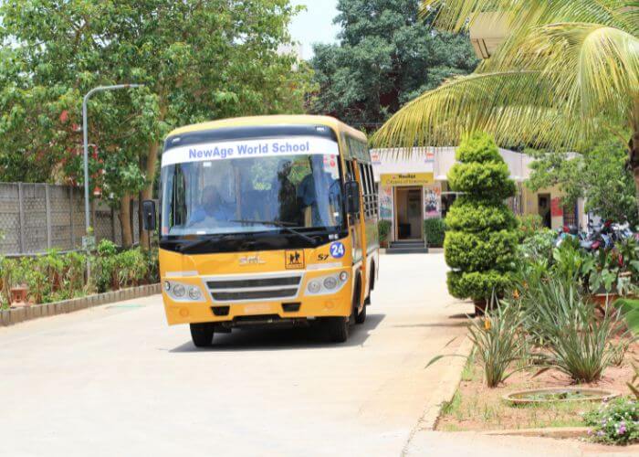 Front view of the NewAge World School bus parked on campus, showcasing their efficient school transport facilities in Yelahanka.