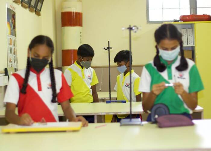 Students using lab equipment for creative problem-solving activities at NewAge World School, among the top schools in Bangalore.