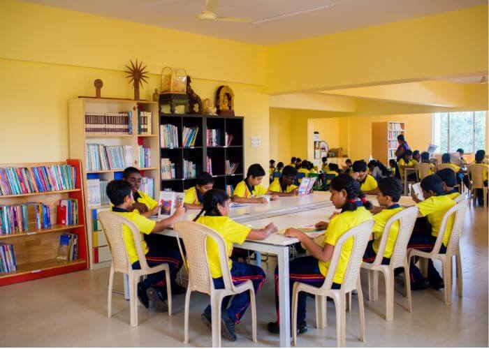 Spacious library with students reading at NewAge World School