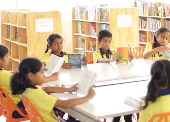Children actively reading and learning in the vibrant library at NewAge World School, Best School in Bangalore.